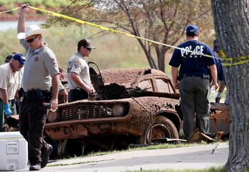 Los agentes de la ley de múltiples agencias examinan los dos autos extraídos del lago en Foss, Oklahoma (Foto: AP/Sue Ogrocki)