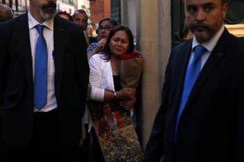 Una mujer llora la muerte del artista español, mientras sostiene un ramo de rosas y una imagen del artista en tamaño grande (Foto: Reuters)