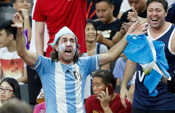 La hinchada Argentina, siempre presente en los mundiales, con simpatizantes chinos que disfrutan del encuentro hablando por teléfono.