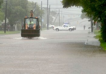 A backhoe drives down a