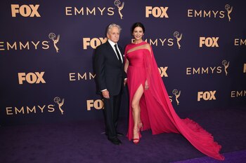 Catherine Zeta-Jones con un diseño fucsia de gasa firmado por el diseñador Georges Hobeika y sandalias a tono de Stuart Weitzman y joyas de Lorraine Schwartz. Michael Douglas la acompañó con un traje negro con corbata a tono y camisa blanca
